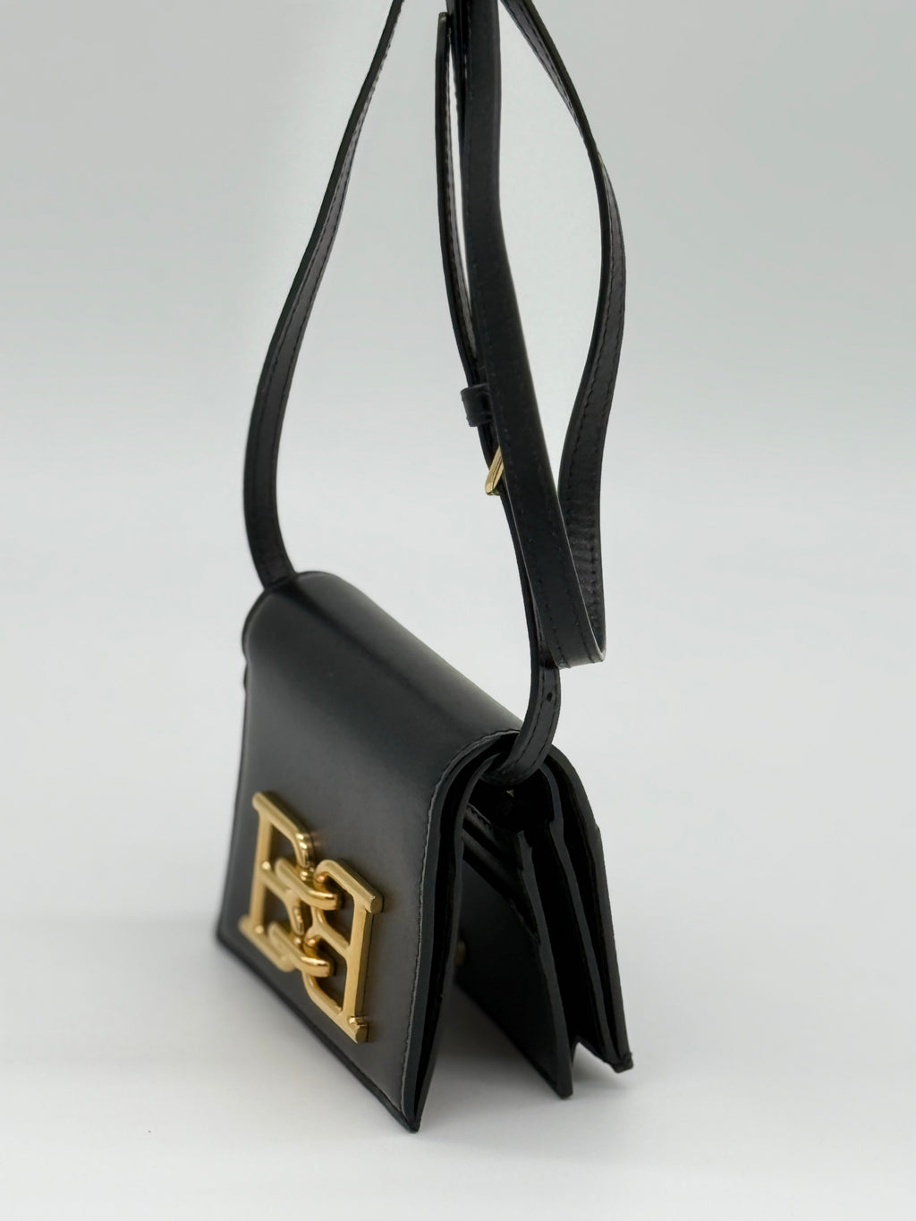 Die Bally schwarze Tasche, dauch las Microbag aus geprägtem Rindsleder, auch als Portemonnaie geeignet. Von links, Crossbody