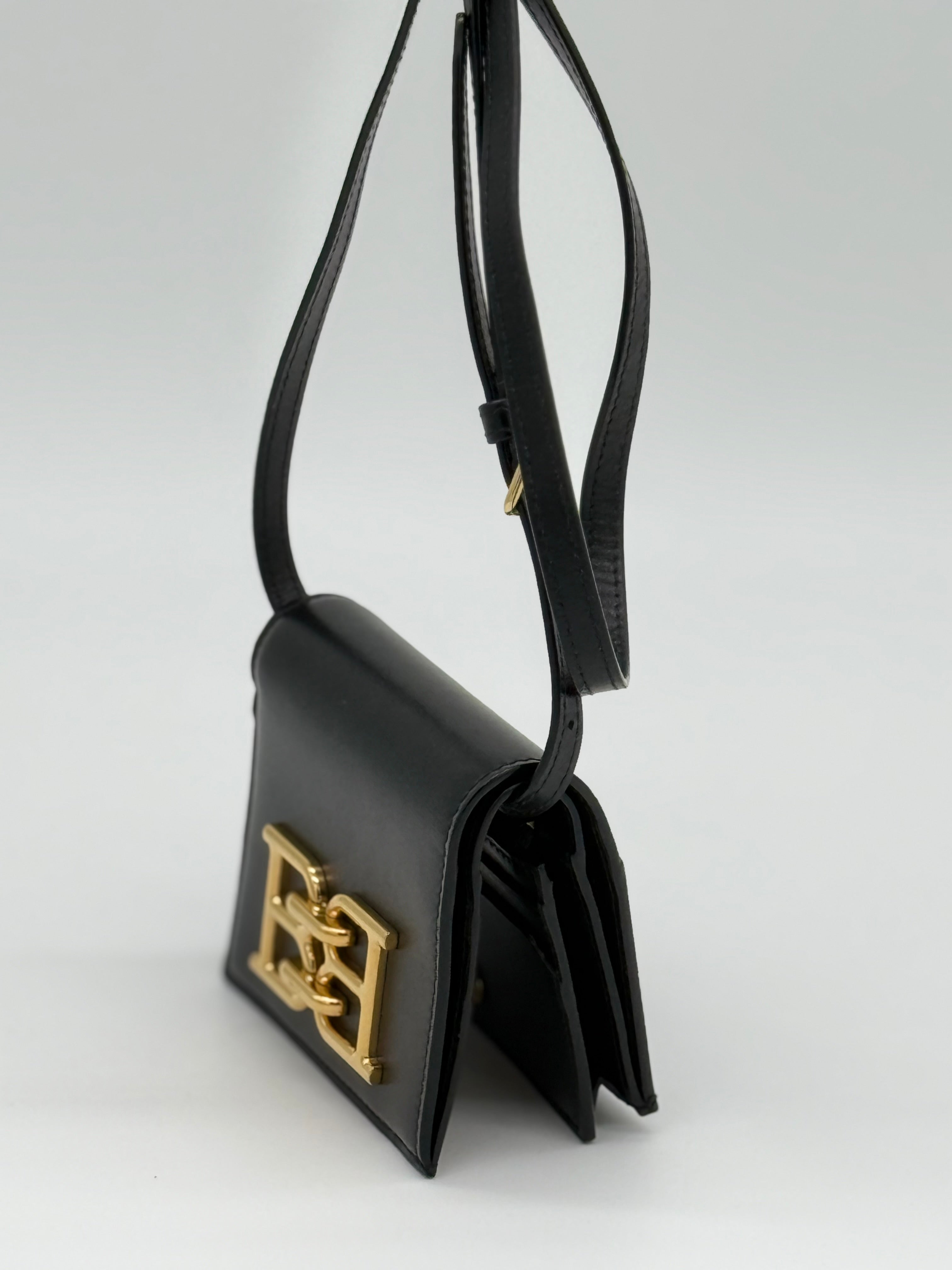 Die Bally schwarze Tasche, dauch las Microbag aus geprägtem Rindsleder, auch als Portemonnaie geeignet. Von links, Crossbody