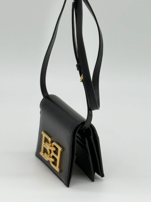 Die Bally schwarze Tasche, dauch las Microbag aus geprägtem Rindsleder, auch als Portemonnaie geeignet. Von links, Crossbody