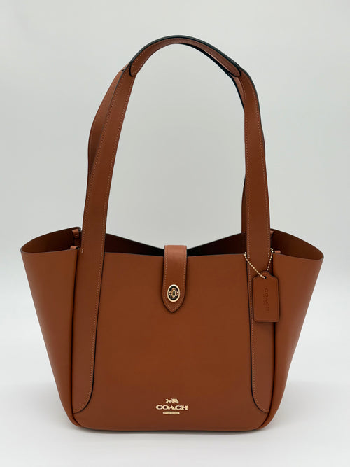 Elegante Coach Tote Bag aus glattem Leder mit praktischem Drehverschluss in Gold und Braun, von vorne
