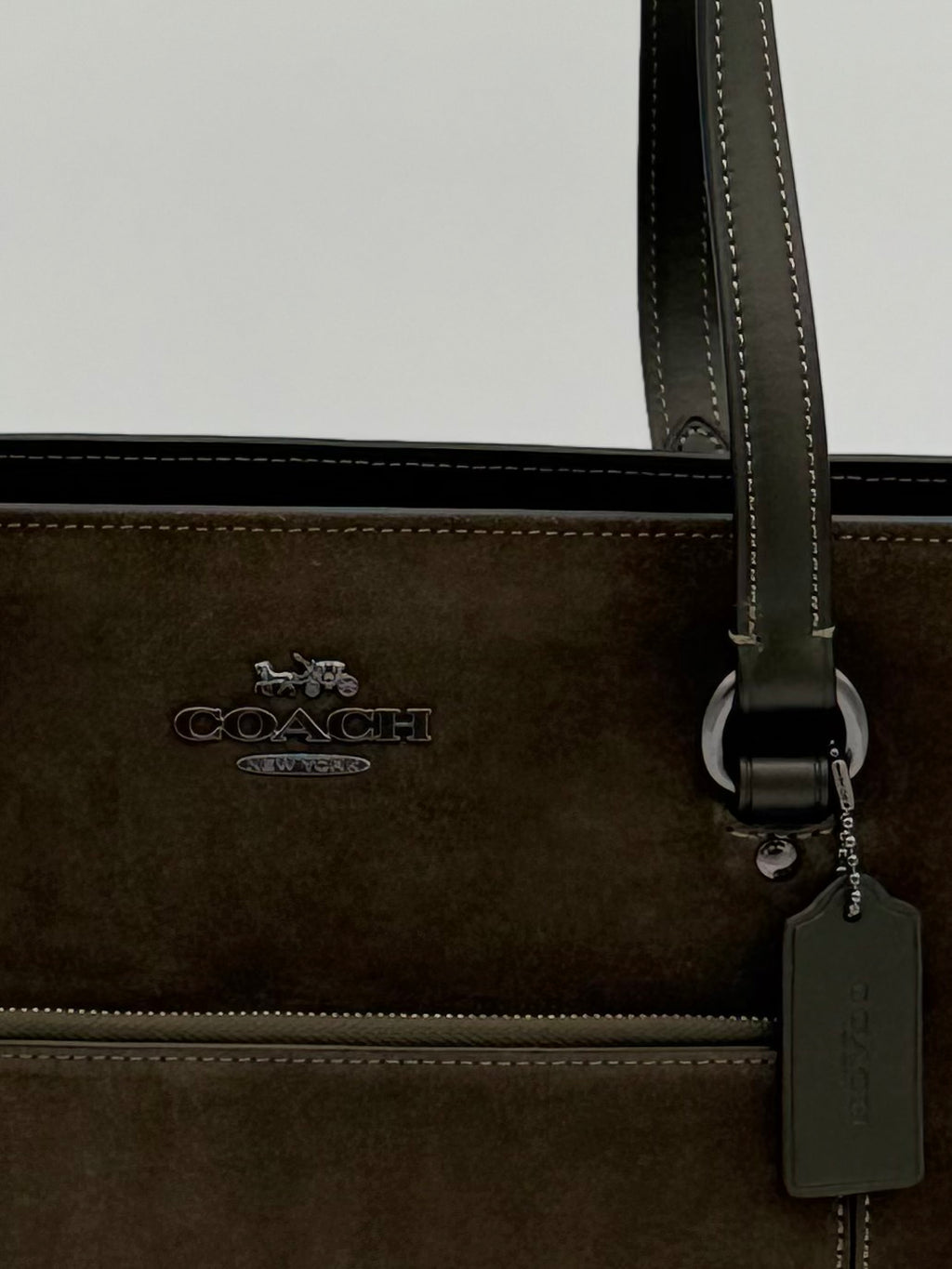 Coach Suede Tote Bag, Green-Army Wildleder Nahaufnahme vom Logo in Metallfarbe schwarz. Vordertasche mit praktischen Reissverschluss 