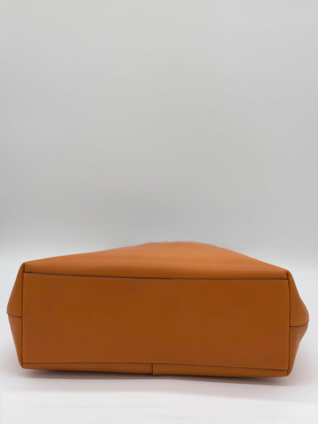 Die Kate Spade 454 Shoulder  Bag, Farbe Orange Jasper, hier unten gezeigt. Der Unterboden ist auch aus glattem Leder.