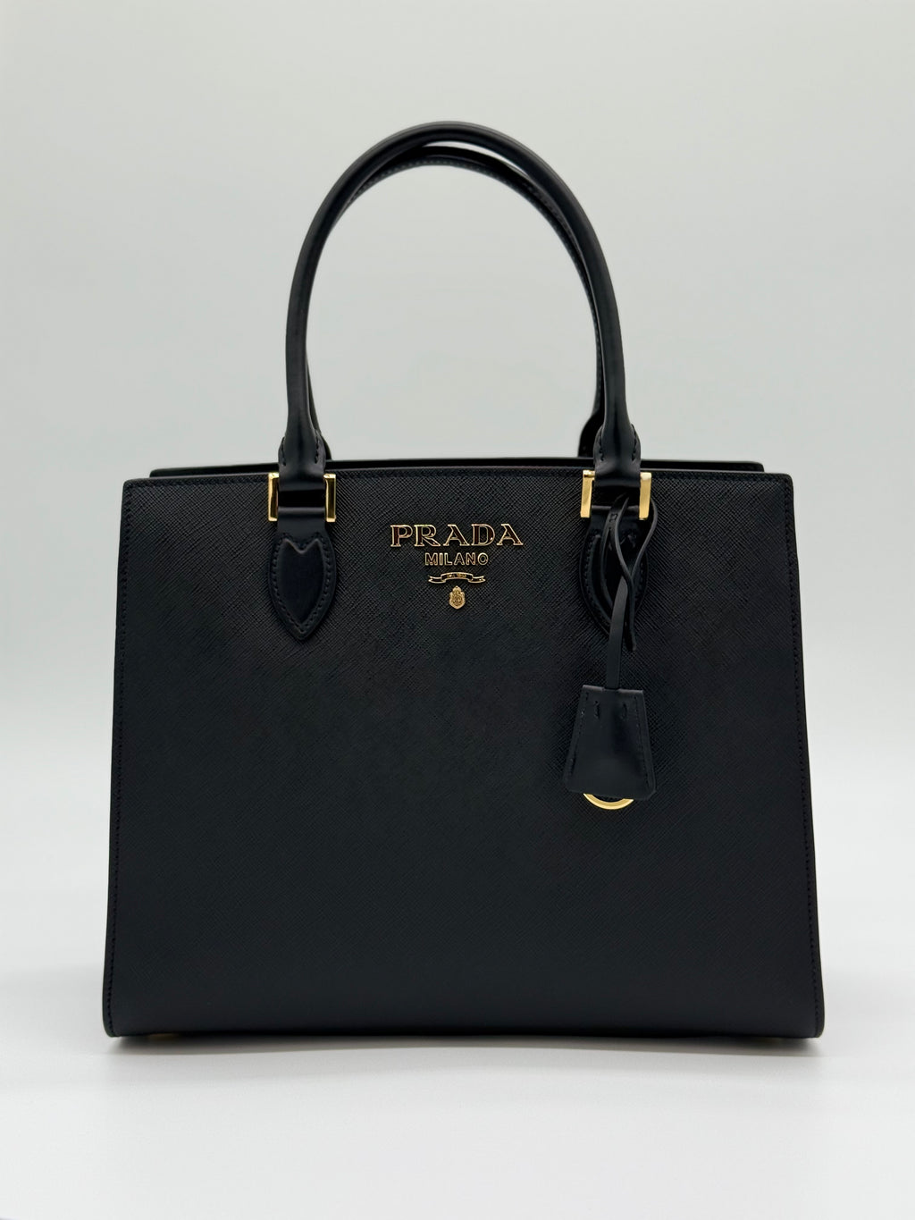 Vorderansicht – „Prada Saffiano Lux Tote Vorderansicht – schwarze Handtasche mit goldenem Prada-Logo