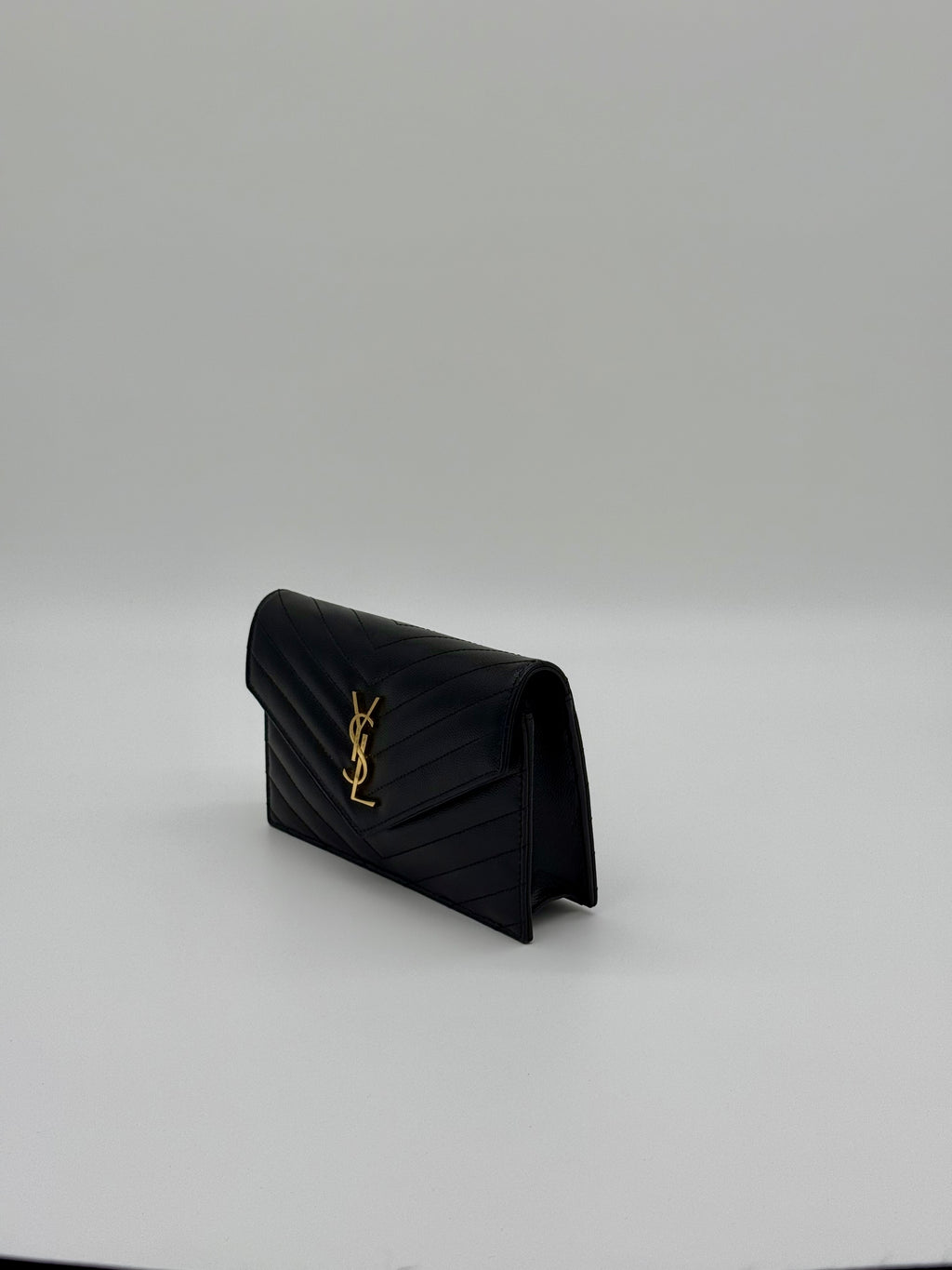 Schräge Seitenansicht der YSL Kettentasche aus schwarzem genarbtem Leder.