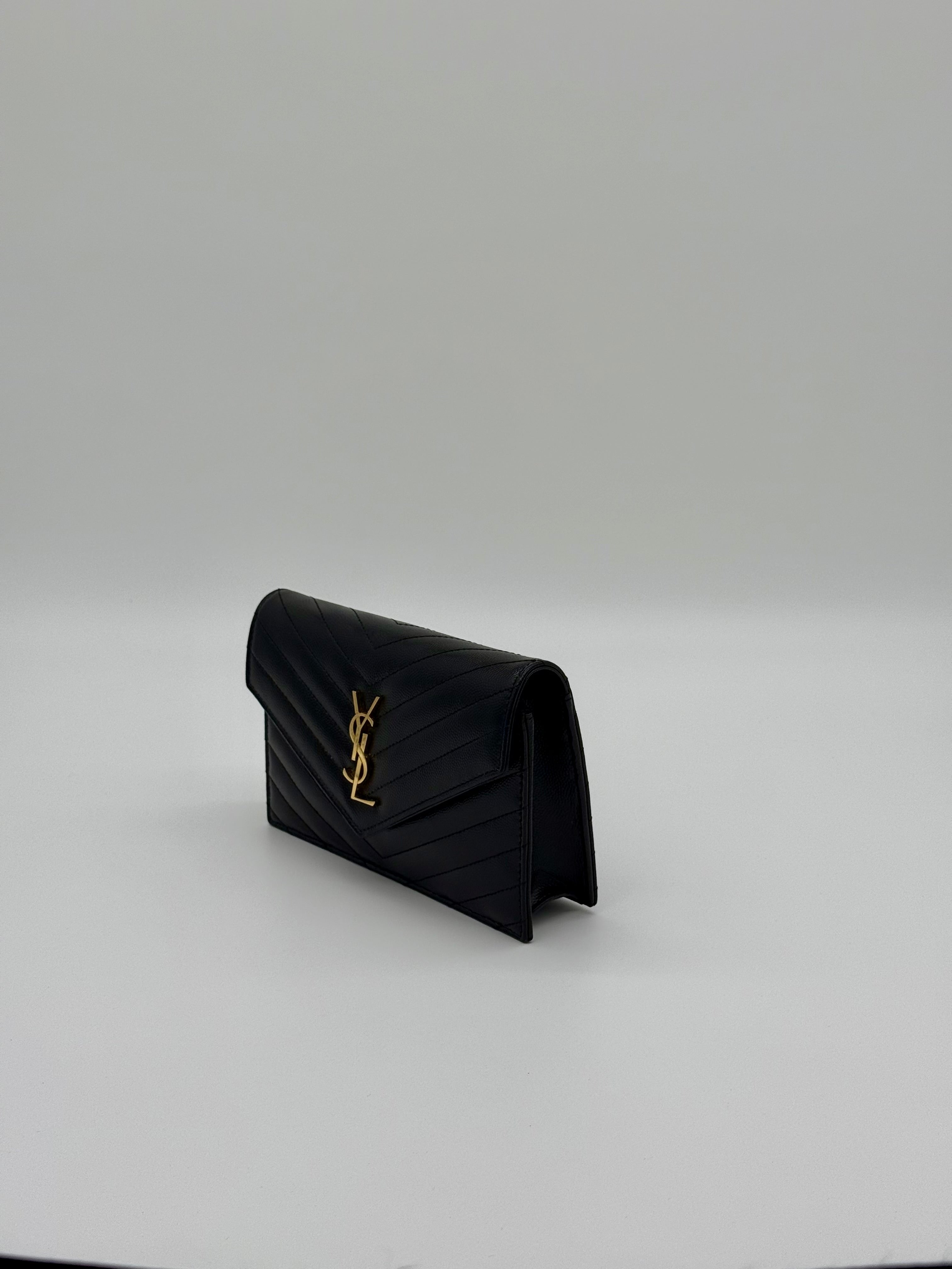 Schräge Seitenansicht der YSL Kettentasche aus schwarzem genarbtem Leder.