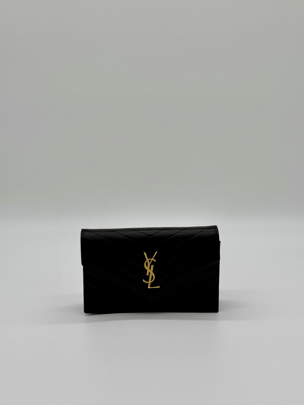 Vorderansicht der Saint Laurent Envelope Cassandre Wallet on Chaîn in Schwarz mit goldenem YSL-Logo.