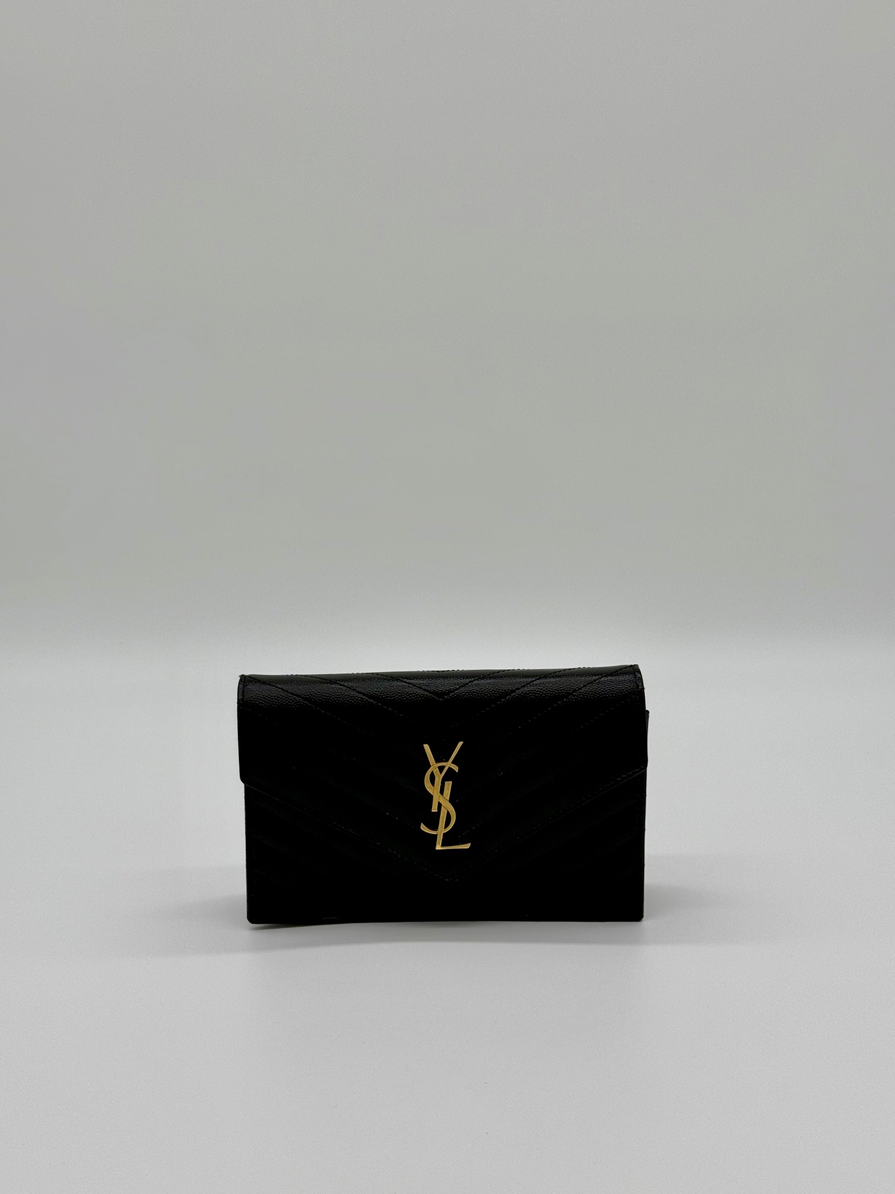 Vorderansicht der Saint Laurent Envelope Cassandre Wallet on Chaîn in Schwarz mit goldenem YSL-Logo.
