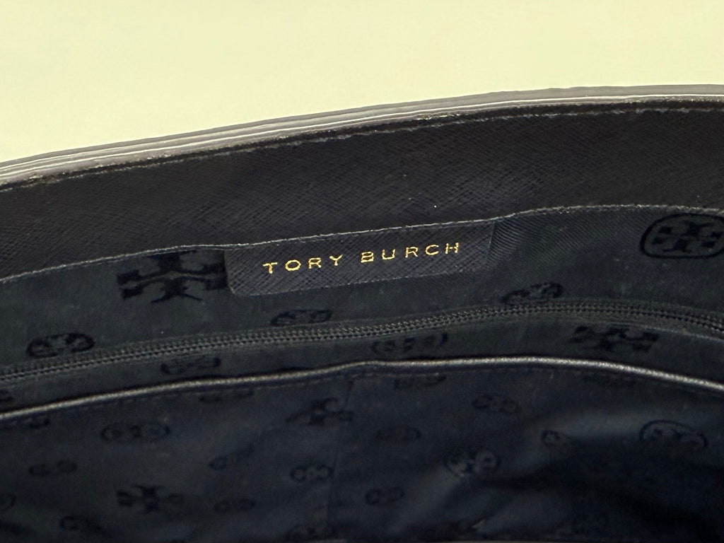 Nahaufnahme des goldenen Tory Burch Logos und Innenfutters mit Markenmuster